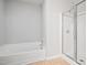 Modern bathroom highlighting a bathtub and shower with glass doors, tiled flooring, and neutral walls at 11220 Avocet Ln # 104, Raleigh, NC 27617