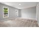 Bright bedroom featuring neutral walls and plush carpet with natural light from the two windows at 11220 Avocet Ln # 104, Raleigh, NC 27617