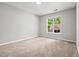Bedroom featuring neutral walls, plush carpet, and natural light from the window at 11220 Avocet Ln # 104, Raleigh, NC 27617