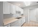 Functional kitchen featuring white cabinets, tile flooring, and essential appliances, providing a tidy and practical cooking area at 11220 Avocet Ln # 104, Raleigh, NC 27617
