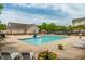 Community pool area with lounge chairs, shade structures, and nearby neighborhood buildings at 11220 Avocet Ln # 104, Raleigh, NC 27617