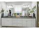 Bright bathroom with granite countertops, white cabinets, double sinks, and two large mirrors at 115 Thornwhistle Pl, Garner, NC 27529
