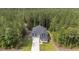 A high-angle view displays a charming two-story home nestled within a dense forest setting at 120 Rocking Horse Ln, Sanford, NC 27332