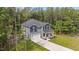 An aerial view showcases a two-story home with an attached garage surrounded by lush greenery and tall trees at 120 Rocking Horse Ln, Sanford, NC 27332