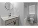 Well-lit bathroom with a modern round mirror, sleek black fixtures, and a tiled floor at 120 Rocking Horse Ln, Sanford, NC 27332