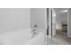 Bright bathroom featuring a soaking tub and an open doorway leading to the bedroom at 120 Rocking Horse Ln, Sanford, NC 27332