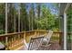 Inviting wooden deck with white rocking chairs and a serene view of the surrounding woods at 120 Rocking Horse Ln, Sanford, NC 27332