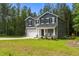 Two-story home with gray siding, a two-car garage, and a welcoming front porch with rocking chairs at 120 Rocking Horse Ln, Sanford, NC 27332