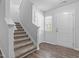 Bright foyer with wood-look floors, carpeted stairs, and natural light from a window at 120 Rocking Horse Ln, Sanford, NC 27332