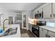 Well-lit kitchen featuring modern appliances, gray cabinets, and a stainless steel sink at 120 Rocking Horse Ln, Sanford, NC 27332