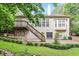 Expansive backyard with a wooden deck, steps, stone patio, and manicured garden beds at 12212 Ashton Woods Ln, Raleigh, NC 27614