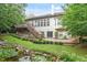 Backyard featuring a pond, wooden deck with steps, stone patio, and meticulous landscaping at 12212 Ashton Woods Ln, Raleigh, NC 27614