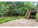 Backyard featuring a stone patio, fountain, and bridge over creek with lush landscaping at 12212 Ashton Woods Ln, Raleigh, NC 27614