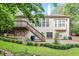 Expansive backyard with manicured lawn, pond, stone patio, water feature, and stairway to deck at 12212 Ashton Woods Ln, Raleigh, NC 27614