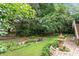 Lush backyard garden with decorative fountain, a stream, and plenty of mature trees for shade at 12212 Ashton Woods Ln, Raleigh, NC 27614