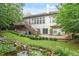 Spacious backyard features a stone patio, water feature, lush garden, and stairway leading to upper deck at 12212 Ashton Woods Ln, Raleigh, NC 27614