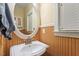 Bathroom featuring a circular mirror and a sink with wood paneled walls at 12212 Ashton Woods Ln, Raleigh, NC 27614