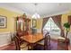 Dining room with a wood table, six chairs, a china cabinet, and natural light at 12212 Ashton Woods Ln, Raleigh, NC 27614