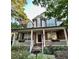 Charming two-story brick home featuring a welcoming front porch with white columns and lush landscaping at 12212 Ashton Woods Ln, Raleigh, NC 27614