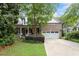 Charming brick home with a manicured lawn, inviting front porch and a two-car garage at 12212 Ashton Woods Ln, Raleigh, NC 27614