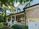 Lovely brick home with a cozy front porch framed by white columns and surrounded by mature trees at 12212 Ashton Woods Ln, Raleigh, NC 27614