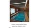 Bright indoor pool area with large windows, wood-paneled walls, and a cool, inviting blue pool at 12212 Ashton Woods Ln, Raleigh, NC 27614