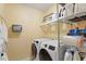 Bright laundry room with modern washer and dryer, and wire rack storage at 12212 Ashton Woods Ln, Raleigh, NC 27614