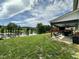 Well-maintained backyard features green grass, large pond, and covered patio with furniture at 123 Claystone Dr, Gibsonville, NC 27249