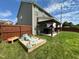 Landscaped backyard featuring a large patio, a sandbox, and ample green space perfect for outdoor activities at 123 Claystone Dr, Gibsonville, NC 27249