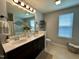 Bright bathroom with double sink vanity, large mirror, tile flooring, and decorative accents at 123 Claystone Dr, Gibsonville, NC 27249