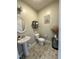 This stylish half-bath features a pedestal sink, toilet, artistic accents, and tiled floors at 123 Claystone Dr, Gibsonville, NC 27249