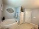 Relaxing bathroom featuring a soaking tub, decorative wall art, neutral tones, and a separate shower area at 123 Claystone Dr, Gibsonville, NC 27249