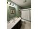 Bathroom with stylish vanity, framed mirror, tiled floor, and shower with curtain at 123 Claystone Dr, Gibsonville, NC 27249