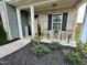 Inviting front porch featuring a seating area, complemented by lush landscaping and a welcoming entrance at 123 Claystone Dr, Gibsonville, NC 27249