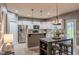 Open concept kitchen with white cabinets, stainless appliances, island and table seating for casual dining at 123 Claystone Dr, Gibsonville, NC 27249