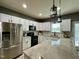 Kitchen featuring white cabinets, granite counters, subway tile backsplash, stainless fridge, and pendant lighting at 123 Claystone Dr, Gibsonville, NC 27249