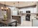 Well-lit kitchen with white cabinets, stainless steel refrigerator, tile backsplash, and adjacent dining area at 123 Claystone Dr, Gibsonville, NC 27249