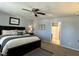 Bedroom featuring a bed with a padded headboard, ceiling fan, carpet and view into the ensuite bathroom at 123 Claystone Dr, Gibsonville, NC 27249