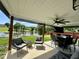 Enjoy outdoor living on this covered patio with pond views, comfortable seating, and ceiling fan at 123 Claystone Dr, Gibsonville, NC 27249