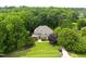 Aerial view of a stunning home nestled among lush, mature trees and manicured lawn at 1308 Woodgate Manor Ct, Raleigh, NC 27614