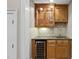 Stylish bar area with a wine cooler, granite countertop, and glass-front cabinets at 1308 Woodgate Manor Ct, Raleigh, NC 27614