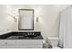 Elegant bathroom with a dark countertop, decorative sconces, and shower-tub combination at 1308 Woodgate Manor Ct, Raleigh, NC 27614