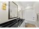 Well-lit bathroom featuring black countertop, brass fixtures, and bathtub-shower combo at 1308 Woodgate Manor Ct, Raleigh, NC 27614