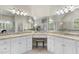 Bathroom featuring double sinks, granite counters, vanity area, and a large framed mirror at 1308 Woodgate Manor Ct, Raleigh, NC 27614