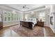 This is a cozy bedroom featuring a wooden sleigh bed, large windows with shutters and a decorative rug at 1308 Woodgate Manor Ct, Raleigh, NC 27614