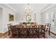 Formal dining room featuring a large wooden table, elegant chandelier and a decorative mirror at 1308 Woodgate Manor Ct, Raleigh, NC 27614