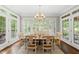 Sunlit dining room with a chandelier, table, and chairs set on a large decorative rug at 1308 Woodgate Manor Ct, Raleigh, NC 27614