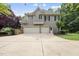 Two-story home with a three-car garage, gray siding, and a well-maintained lawn at 1308 Woodgate Manor Ct, Raleigh, NC 27614