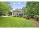 Two-story home with a screened-in porch, gray siding, and a large lawn, surrounded by mature trees at 1308 Woodgate Manor Ct, Raleigh, NC 27614