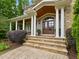 Inviting front entrance with stone steps, detailed pillars, and double wooden doors at 1308 Woodgate Manor Ct, Raleigh, NC 27614